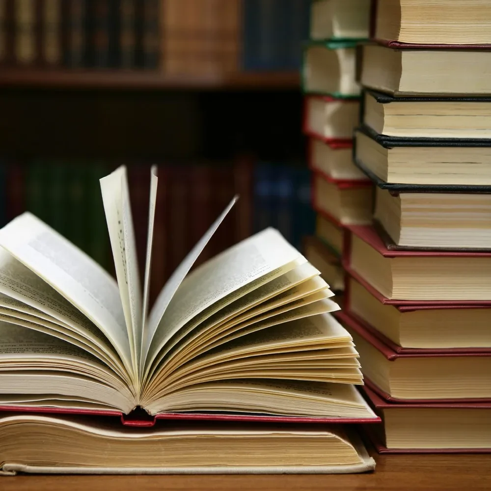 Livre ouvert et pile de llivres, illustration du parcours professionnel et de la formation